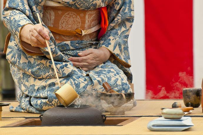 Japanerin giesst heisse Wasser in die Teekanne
